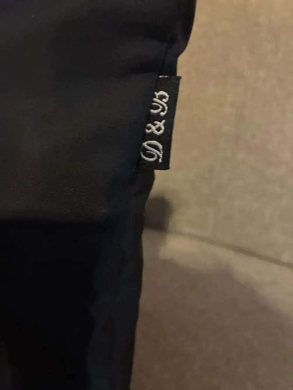 Dooney & Bourke Wayfarer Zip Tote in black nylon with Vachetta leather trim. Wit